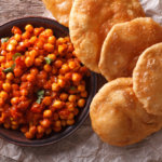 Delicious Indian Chana masala and puri bread close-up on the table.